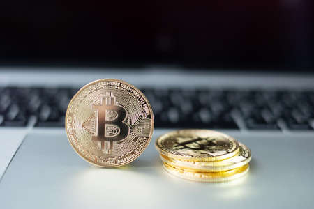 golden Bitcoin cryptocurrency coin stack on laptop keyboard, Crypto is Digital Money within the...