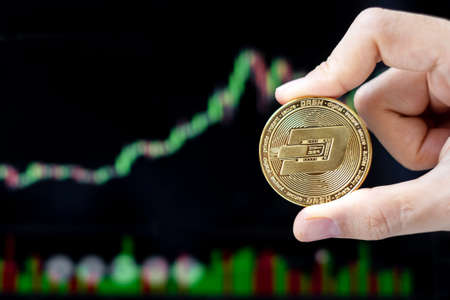 Golden Dash cryptocurrency coin with candle graph background, Crypto is Digital Money within the blockchain network, is using technology and online internet exchange.の写真素材