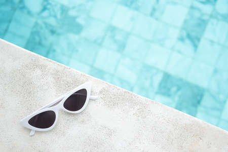 white sunglasses near swimming pool in luxury hotel. Summer travel, vacation, holiday and weekend conceptの写真素材