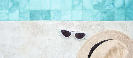 white sunglasses and hat near swimming pool in luxury hotel. Summer travel, vacation, holiday and weekend conceptの写真素材
