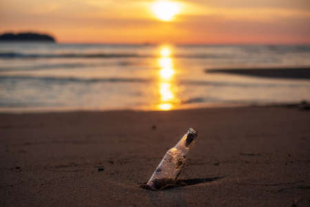 Glass Bottle garbage on the beach against sunset background. Ecology,  Environmental, pollution and Ecological problem conceptの写真素材
