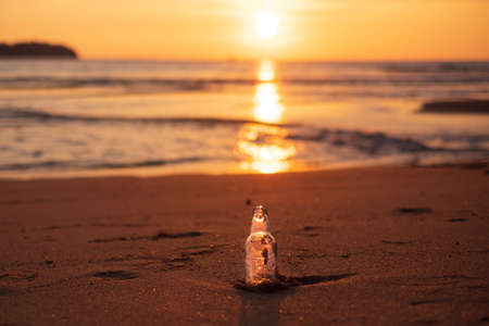 Glass Bottle garbage on the beach against sunset background. Ecology,  Environmental, pollution and Ecological problem conceptの写真素材