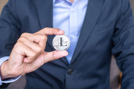 Businessman hand holding Silver Litecoin (LTC) cryptocurrencyの写真素材