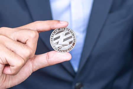 Businessman hand holding Silver Litecoin (LTC) cryptocurrencyの写真素材