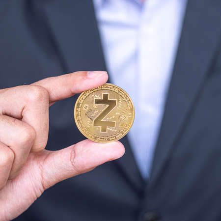 Businessman hand holding golden ZCASH (ZEC) cryptocurrency coinの写真素材