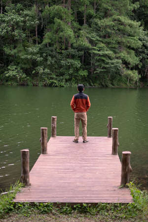 Happy traveler man standing and looking Nature view, solo tourist in sweater traveling at Pang Oung, Mae Hong Son, Thailand. travel, trip and vacation conceptの写真素材