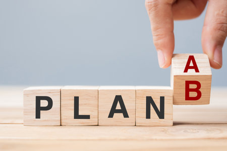 Businessman hand flipping wooden cube blocks with PLAN A change to PLAN B text on table background. strategy, leadership, management, marketing, project and Crisis conceptsの写真素材