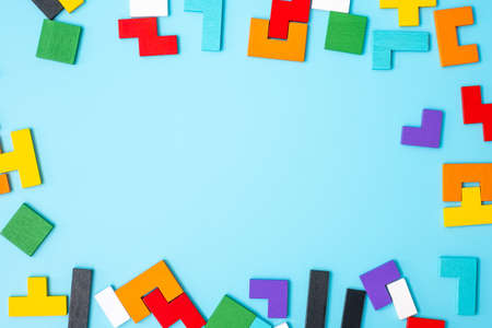 colorful wood puzzle pieces on blue background, geometric shape block with copy space. Concepts of...