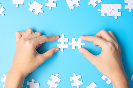 Hands connecting couple white puzzle jigsaw piecesの写真素材