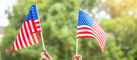 hand holding United States of America flag on green background. USA holiday of Veterans, Memorial, Independence ( Fourth of July) and Labor Day conceptの写真素材