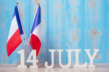 Wooden calendar of July 14th with miniature France flags. French National Day, Bastille Day and happy celebration conceptsの写真素材