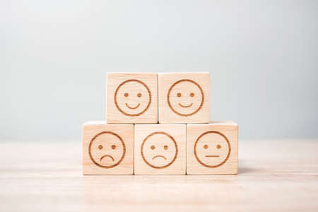 emotion face symbol on wooden blocks. Service rating, ranking, customer review, satisfaction, evaluation and feedback conceptの写真素材