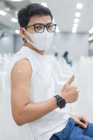Happy man showing thumb after receiving vaccine. Vaccination, immunization, inoculation