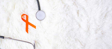 Leukemia, Kidney cancer day, world Multiple Sclerosis, CRPS, Self Injury Awareness month, Orange Ribbon with stethoscope for support people living and illness. Healthcare and World cancer day conceptの写真素材