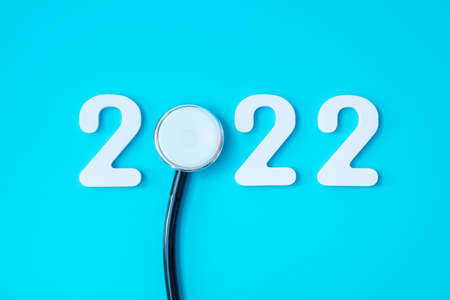 2022 Happy New Year for healthcare, Insurance, Wellness and medical concept. Stethoscope and white number on blue backgroundの写真素材