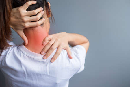 woman with her neck sprain, muscle painful during overwork. Girl having body problem after wake up. Stiff neck, office syndrome and ergonomic conceptの写真素材