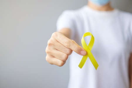 hand holding Yellow Ribbon for supporting people living and illness. September Suicide prevention...