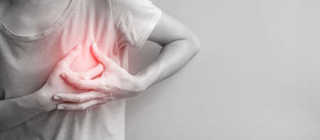 woman hands holding chest ache. Breast cancer, angina disease and symptom heart attack diseaseの写真素材