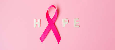 October Breast Cancer Awareness month, Pink Ribbon with HOPE text on pink background for supporting people living and illness. International Women, Mother and World cancer day conceptの写真素材