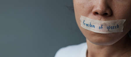 woman with mouth sealed in adhesive tape with Freedom  of Speech message., freedom of press, Human rights, Protest dictatorship, democracy, liberty, equality and fraternity conceptsの写真素材