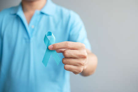 November Prostate Cancer Awareness month, Man in blue shirt with hand holding Blue Ribbon for supporting people living and illness. Healthcare, International men, Father and World cancer day conceptの写真素材