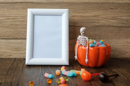 Orange pumpkin bowl and candies on table and frame with copy space for text. Happy Halloween day, Hello October, fall autumn season, Festive, party and holiday conceptの写真素材