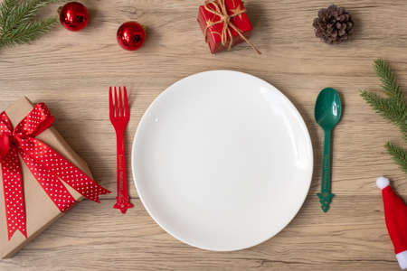 Merry Christmas with plate, fork and spoon on wood table background. Xmas, party and happy New Year conceptの写真素材