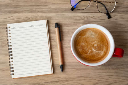 blank notebook and coffee cup on wood table. Motivation, Resolution, To do list, Strategy and Plan conceptの写真素材
