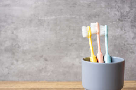 Set of Toothbrushes in cup on wall background at bathroom. World oral health day and free dental day conceptの写真素材