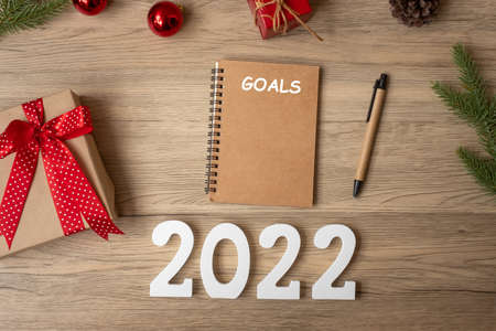2022 GOAL with notebook, Christmas gift and pen on wood table. Xmas, Happy New Year, Resolution, To do list, start, Strategy and Plan conceptの写真素材