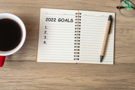 2022 GOAL with notebook, black coffee cup and pen on wood table, Top view and copy space. Happy New Year, Resolution, To do list, Strategy and Plan conceptの写真素材