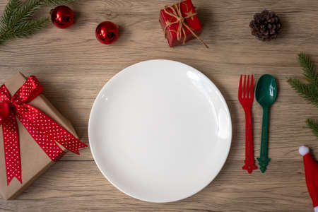 Merry Christmas with plate, fork and spoon on wood table background. Xmas, party and happy New Year conceptの写真素材