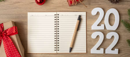 2022 New Year with notebook, Christmas gift and pen on wood table. Xmas, Happy New Year, Goals, Resolution, To do list, start, Strategy and Plan conceptの写真素材