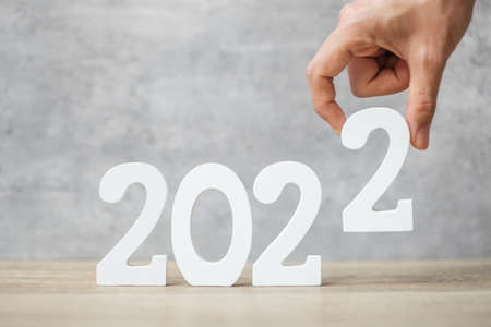 hand change 2021 to 2022 number on table. Plan, finance, Resolution, strategy, solution, goal, business and New Year holiday conceptsの写真素材