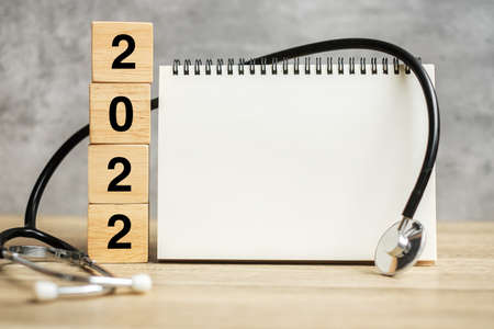 2022 Happy New Year for healthcare, Insurance, Wellness and medical concept. Stethoscope and blank notebook for copy space your textの写真素材