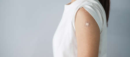 woman showing bandage after receiving vaccine. Vaccination, herd immunity, side effect, booster.の写真素材