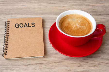 GOAL with notebook and coffee cup on wood table. Motivation, Resolution, To do list, Strategy and Plan conceptの写真素材