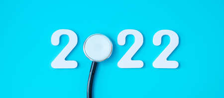 2022 Happy New Year for healthcare, Insurance, Wellness and medical concept. Stethoscope and white number on blue backgroundの写真素材