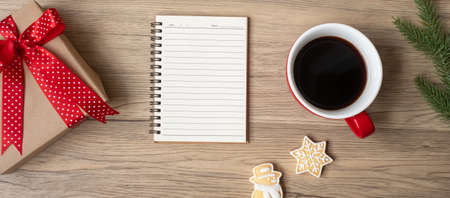 Blank notebook, black coffee cup, Christmas cookies and pen on wood table, Top view and copy space. Xmas, Happy New Year, Goals, Resolution, To do list, Strategy and Plan conceptの写真素材