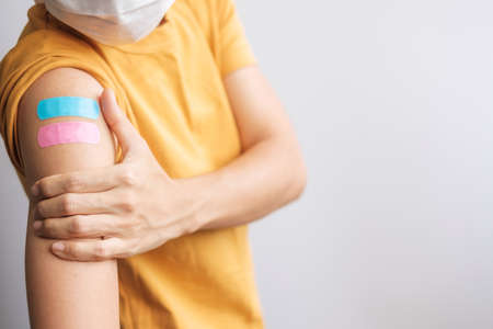 woman showing plaster after receiving covid 19 vaccine. Vaccination, herd immunity, side effect,...
