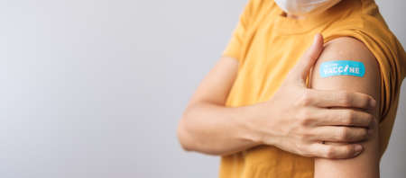 woman showing bandage after receiving covid 19 vaccine. Vaccination, herd immunity, side effect,...