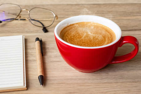 blank notebook and coffee cup on wood table. Motivation, Resolution, To do list, Strategy and Plan conceptの写真素材