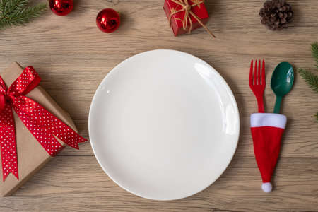 Merry Christmas with plate, fork and spoon on wood table background. Xmas, party and happy New Year conceptの写真素材