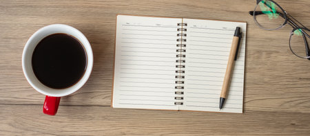 Blank notebook, black coffee cup and pen on wood table, Top view and copy space. Happy New Year, Goals, Resolution, To do list, Strategy and Plan conceptの写真素材