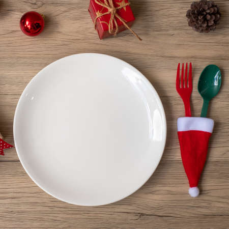 Merry Christmas with plate, fork and spoon on wood table background. Xmas, party and happy New Year conceptの写真素材