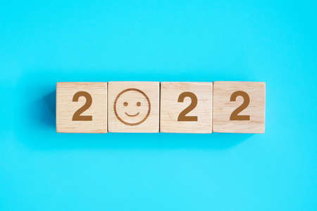 Smile face block with 2022 text on blue background. Satisfaction, feedback, Review and New Year conceptsの写真素材