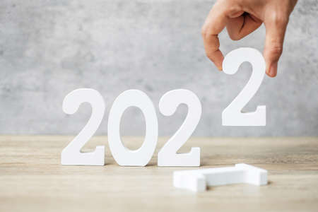 hand change 2021 to 2022 number on table. Plan, finance, Resolution, strategy, solution, goal, business and New Year holiday conceptsの写真素材