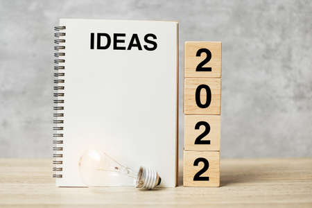 2022 text wood cube blocks and IDEAS word with lightbulb on table. New Year New Ideas, Creative, Innovation, Imagination, inspiration, Resolution, Strategy and goal conceptの写真素材
