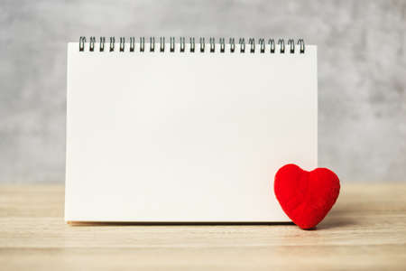 red heart shape and empty notebook on table for your text. Resolution, Goal, plan, health, Love, romantic and Valentine Day holiday Conceptの写真素材
