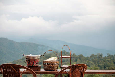 Pork or meat with vegetables and soup on the hot pan against mountain view background, Traditional Thai BBQ style is famous in Thailandの写真素材